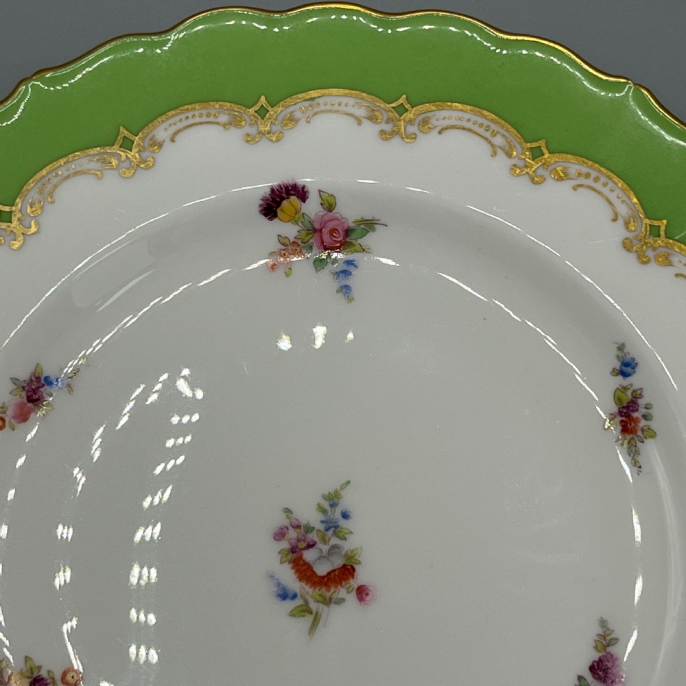 A pair of Victorian Coalport porcelain plates with bright green scalloped borders, gilded scrollwork, and hand-painted floral sprays on white centres. View XVIII