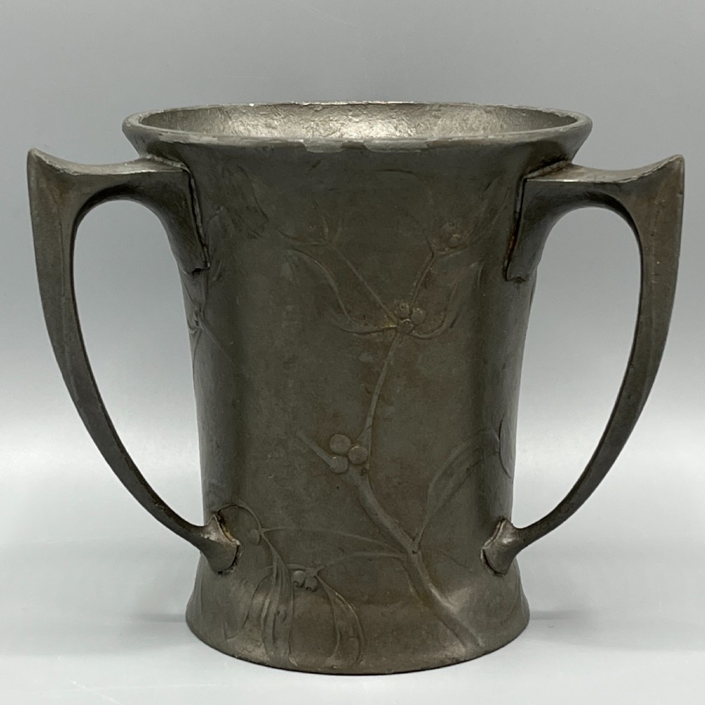 A grey pewter Art Nouveau tyg vase featuring three curved handles and relief-moulded mistletoe motifs around the body. View II