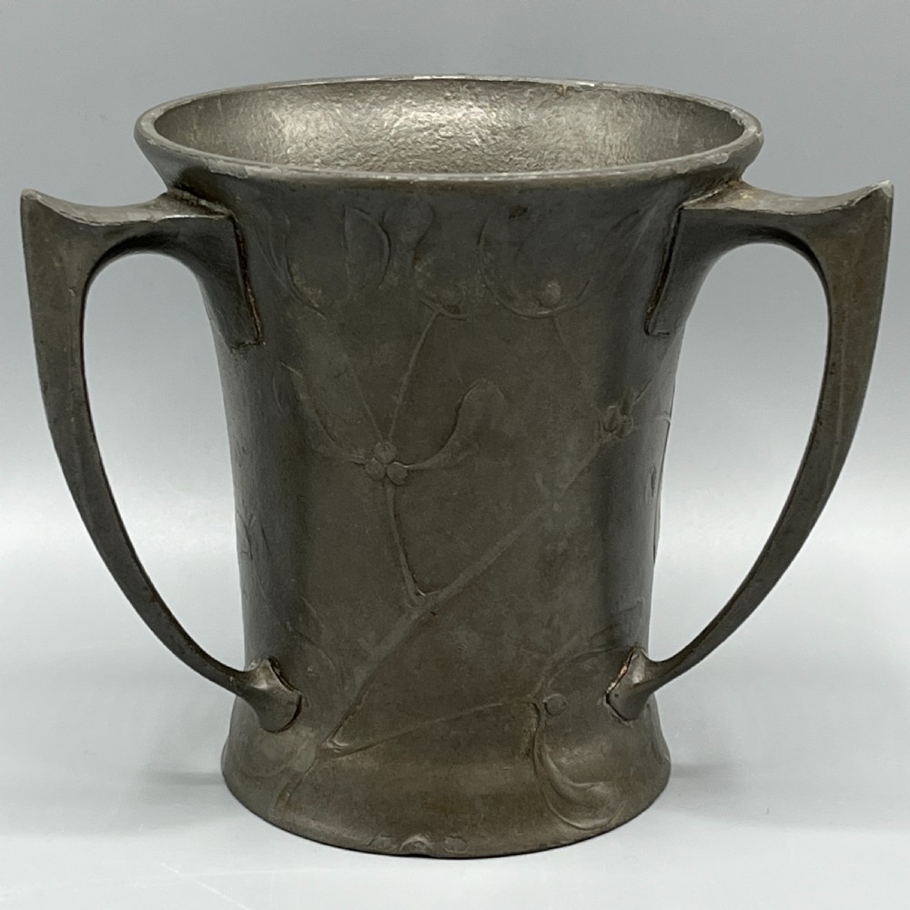A grey pewter Art Nouveau tyg vase featuring three curved handles and relief-moulded mistletoe motifs around the body. View III