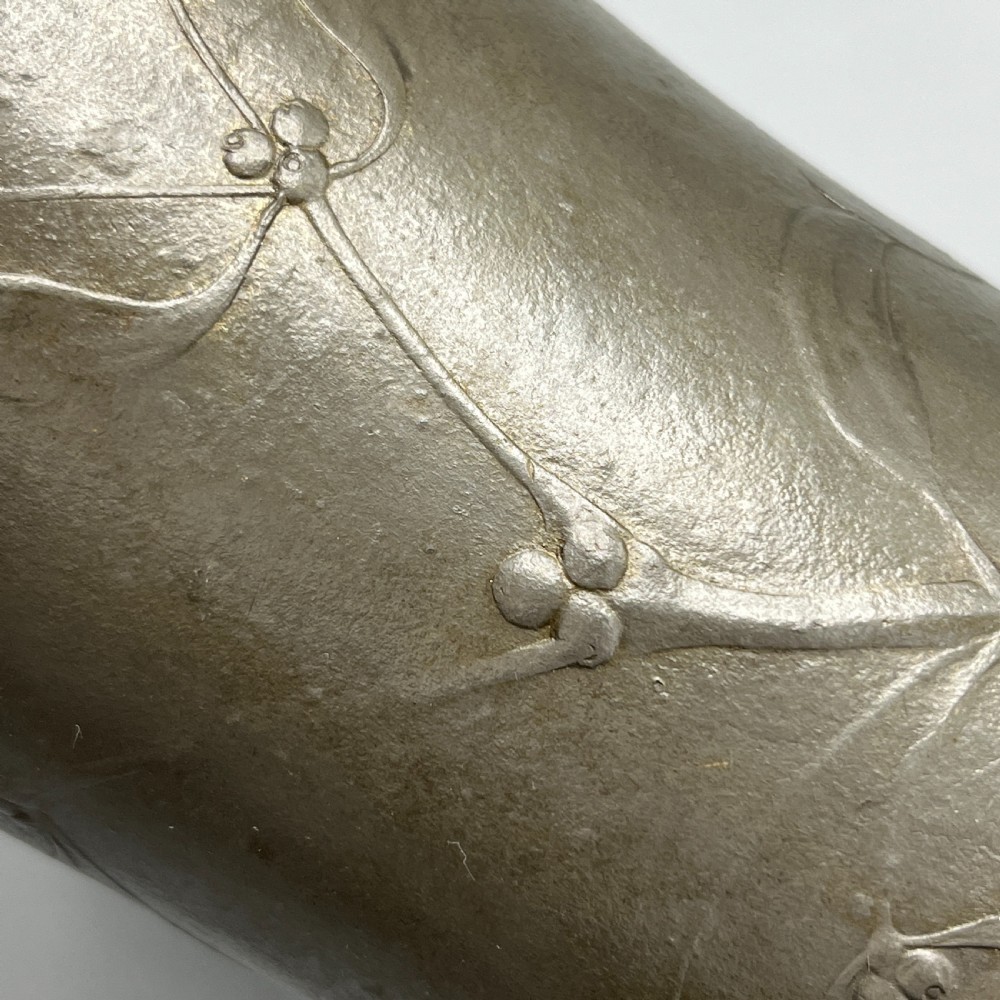 A grey pewter Art Nouveau tyg vase featuring three curved handles and relief-moulded mistletoe motifs around the body. View XI