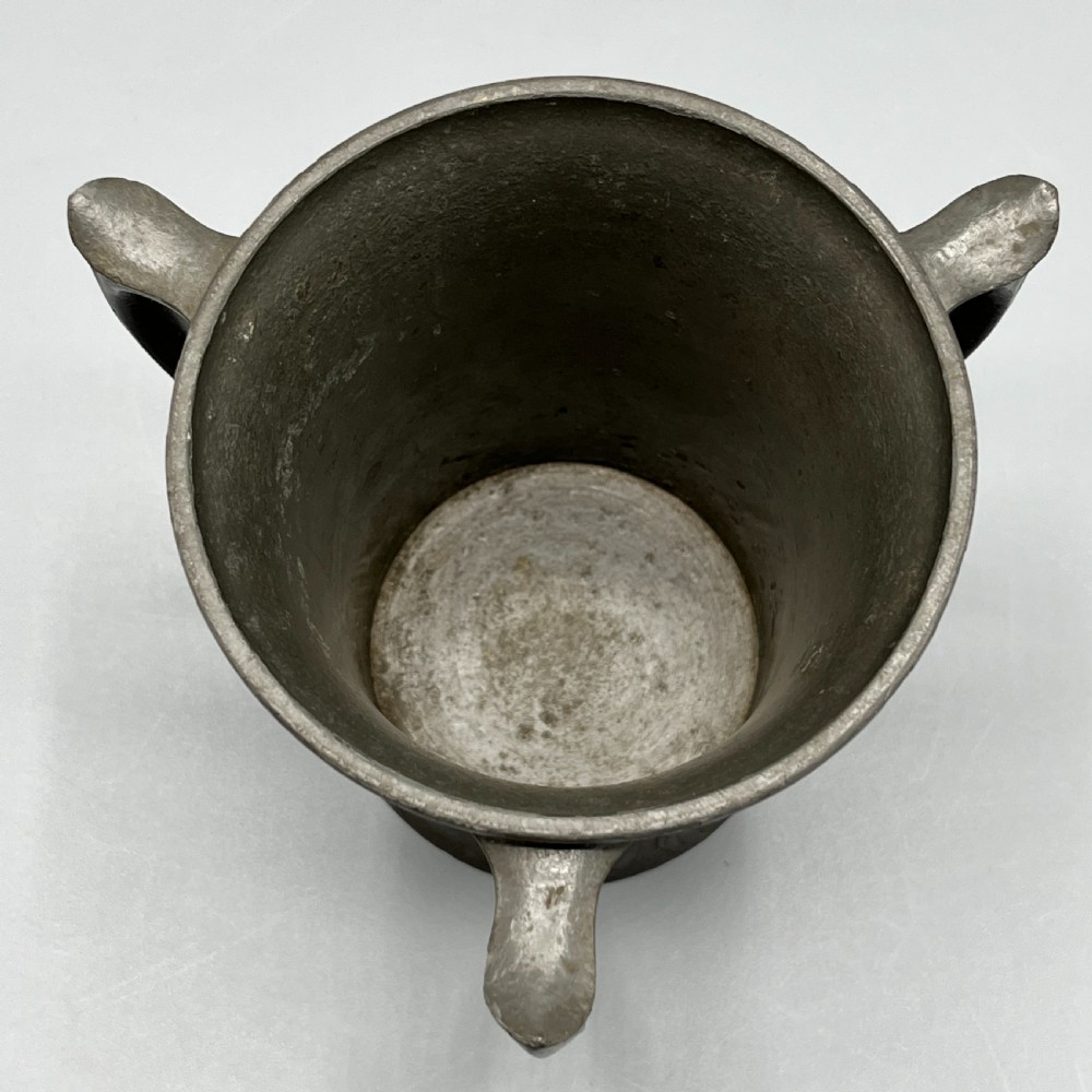 A grey pewter Art Nouveau tyg vase featuring three curved handles and relief-moulded mistletoe motifs around the body. View XII