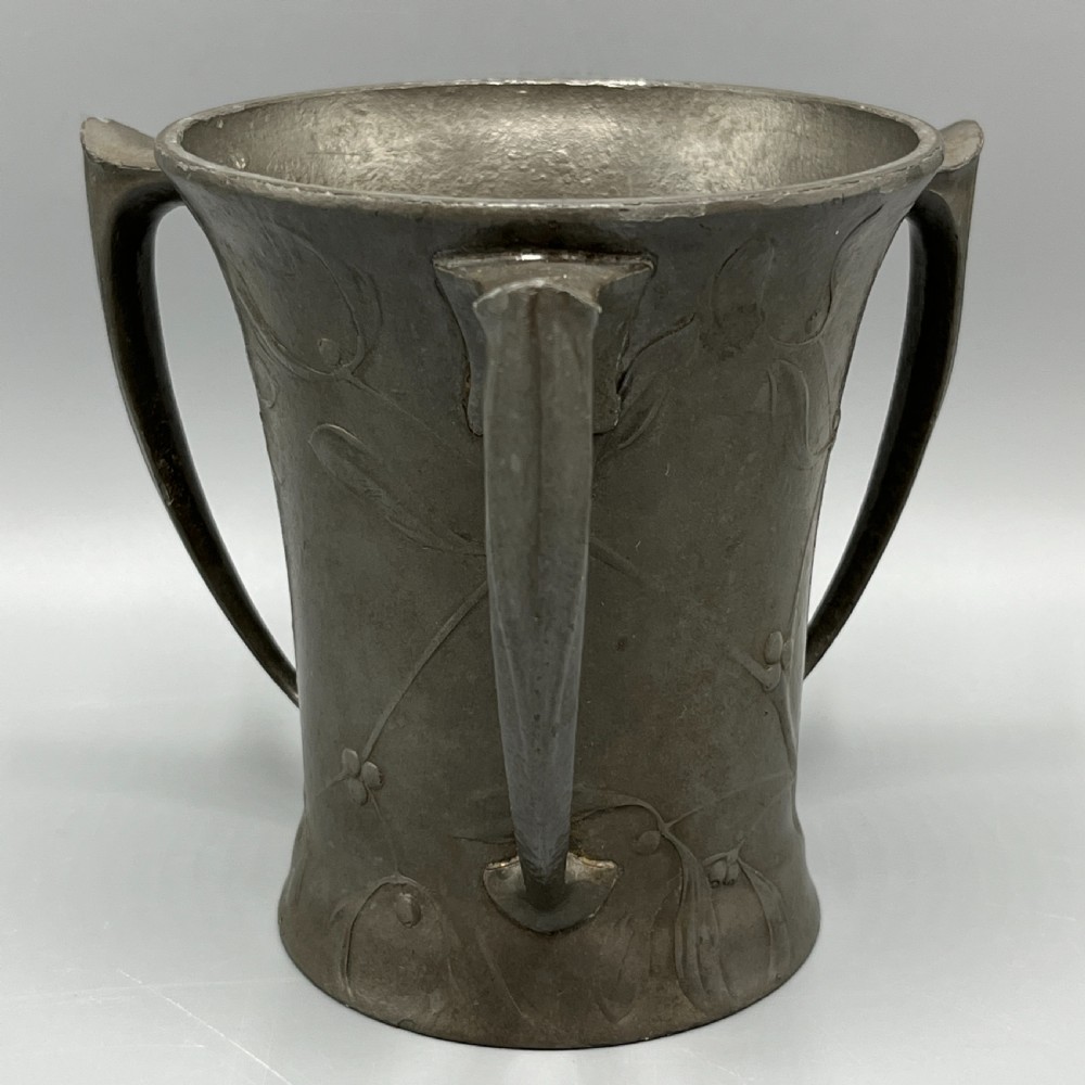 A grey pewter Art Nouveau tyg vase featuring three curved handles and relief-moulded mistletoe motifs around the body. View XIV