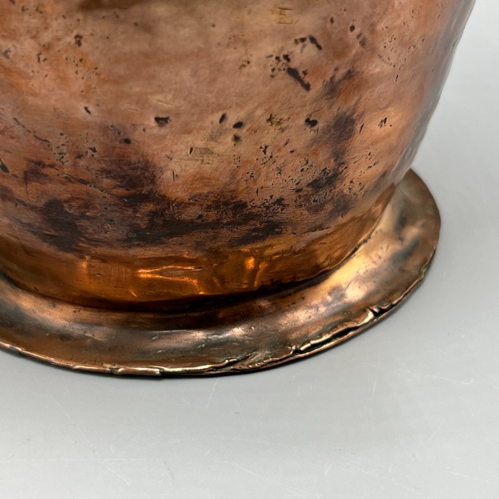 An antique Georgian copper jug featuring a hand-hammered body, wide pouring spout, flared base, and a riveted loop handle. View XIV