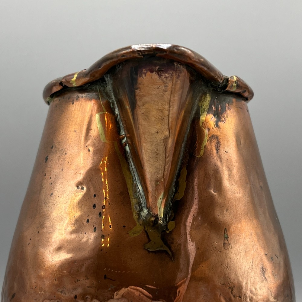 An antique Georgian copper jug featuring a hand-hammered body, wide pouring spout, flared base, and a riveted loop handle. View XV