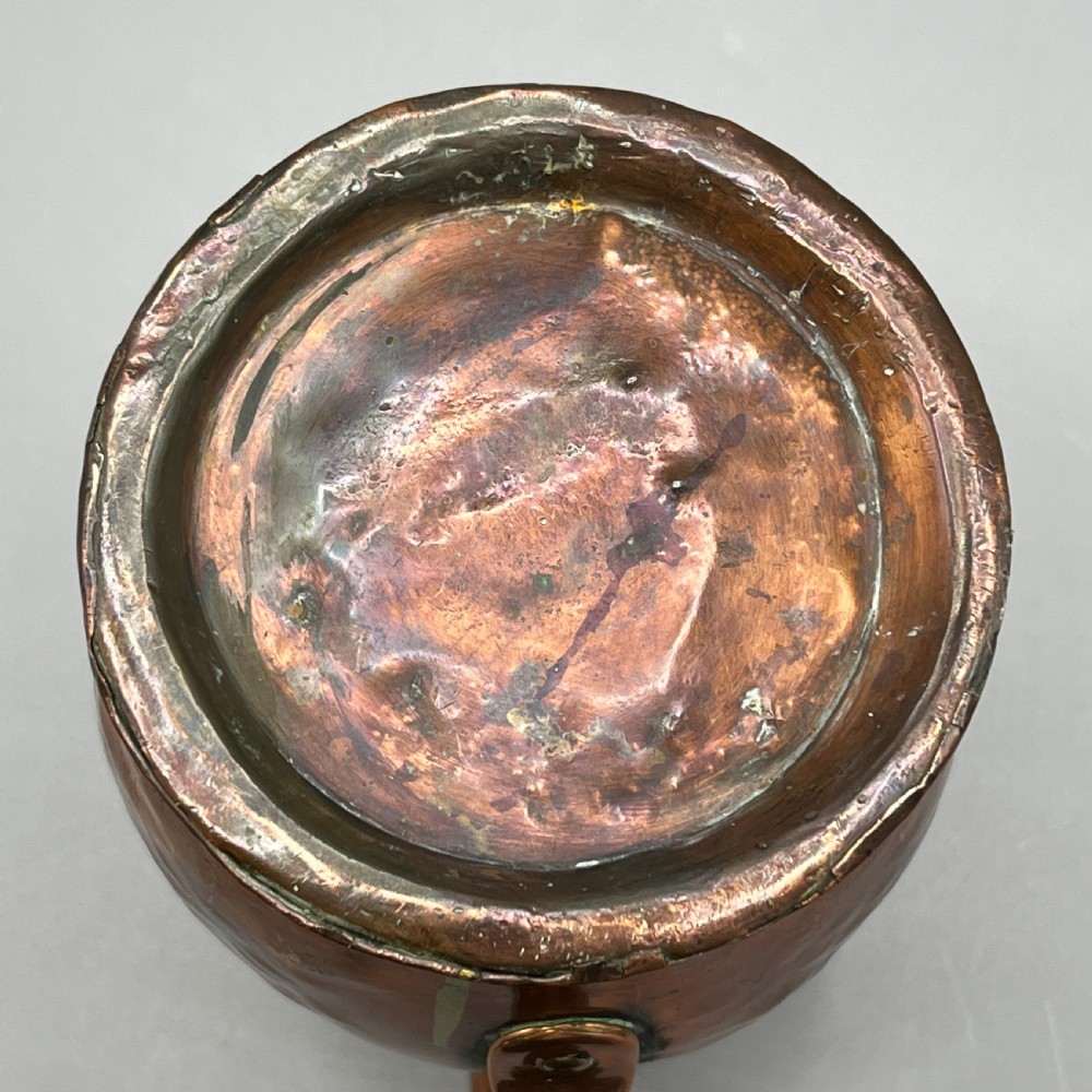 An antique Georgian copper jug featuring a hand-hammered body, wide pouring spout, flared base, and a riveted loop handle. View XVIII