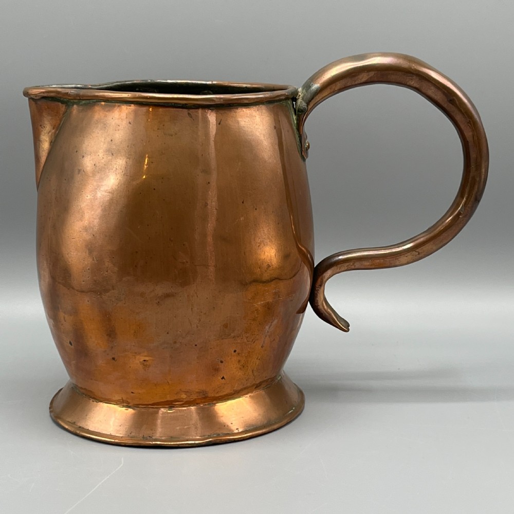 A Georgian copper jug featuring a bulbous body, a flared circular base, a pinched pouring spout, and a large curved loop handle. View II