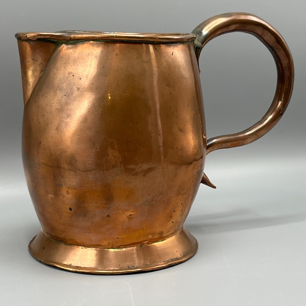 A Georgian copper jug featuring a bulbous body, a flared circular base, a pinched pouring spout, and a large curved loop handle. View III