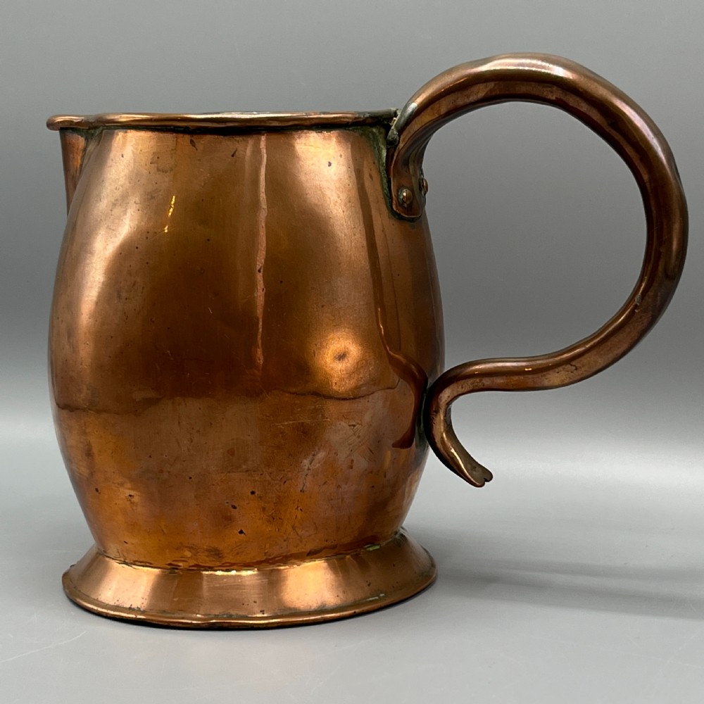 A Georgian copper jug featuring a bulbous body, a flared circular base, a pinched pouring spout, and a large curved loop handle. View IV