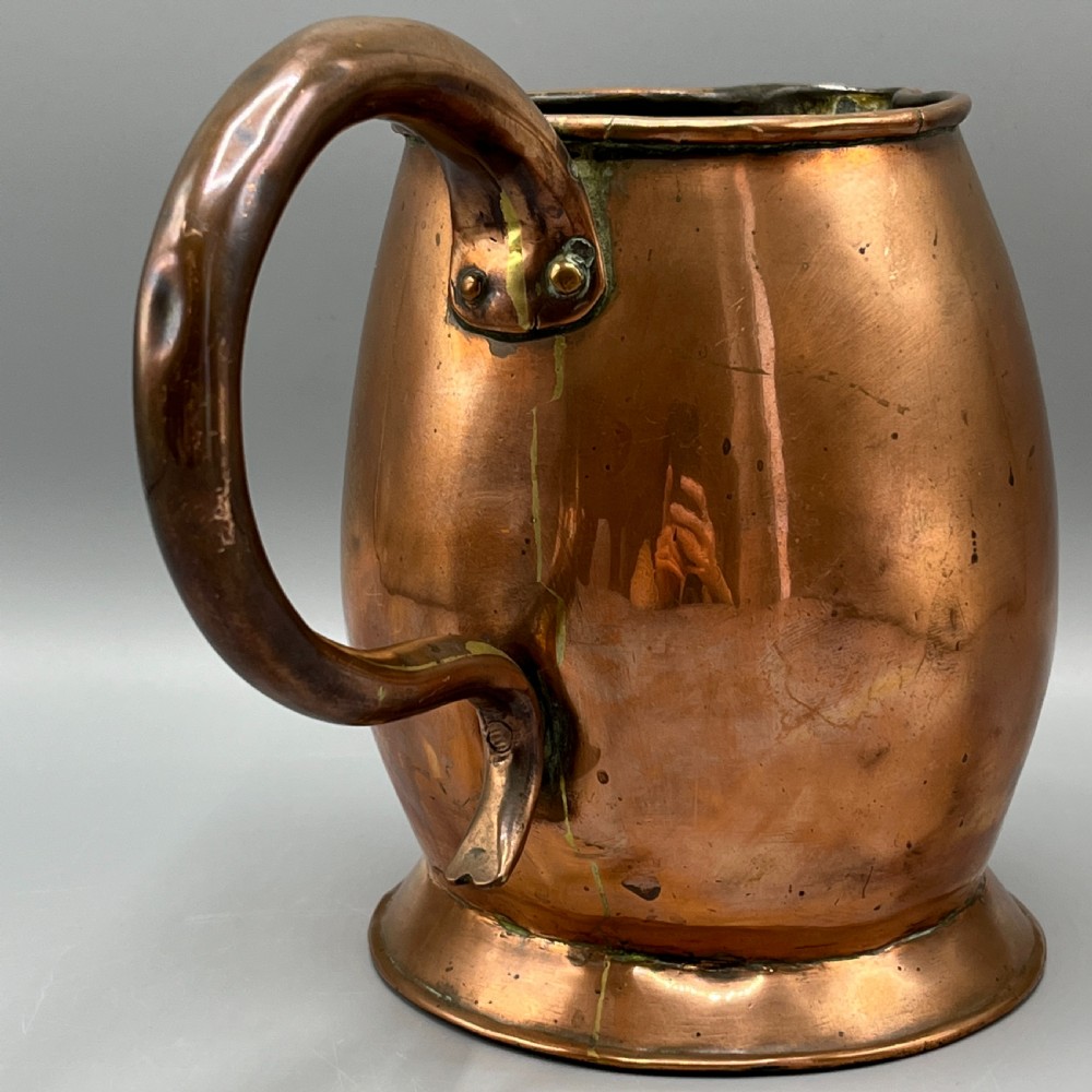 A Georgian copper jug featuring a bulbous body, a flared circular base, a pinched pouring spout, and a large curved loop handle. View VI