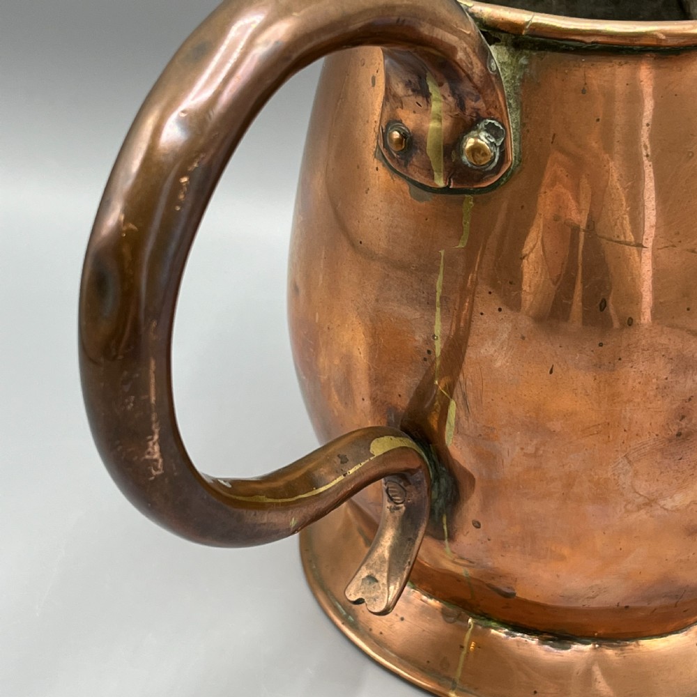 A Georgian copper jug featuring a bulbous body, a flared circular base, a pinched pouring spout, and a large curved loop handle. View VII