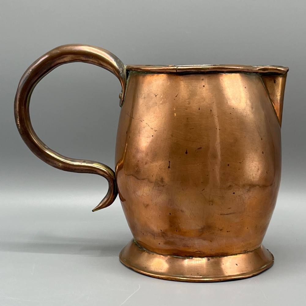 A Georgian copper jug featuring a bulbous body, a flared circular base, a pinched pouring spout, and a large curved loop handle. View VIII