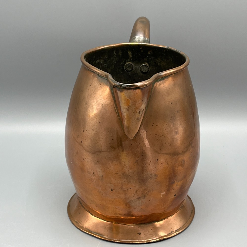 A Georgian copper jug featuring a bulbous body, a flared circular base, a pinched pouring spout, and a large curved loop handle. View XI