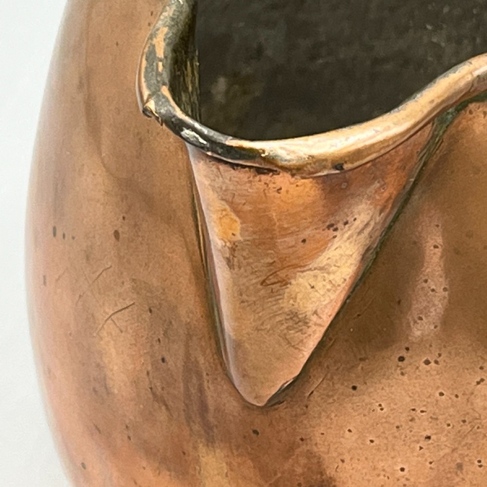 A Georgian copper jug featuring a bulbous body, a flared circular base, a pinched pouring spout, and a large curved loop handle. View XII