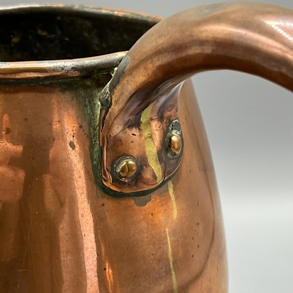 A Georgian copper jug featuring a bulbous body, a flared circular base, a pinched pouring spout, and a large curved loop handle. View XIV