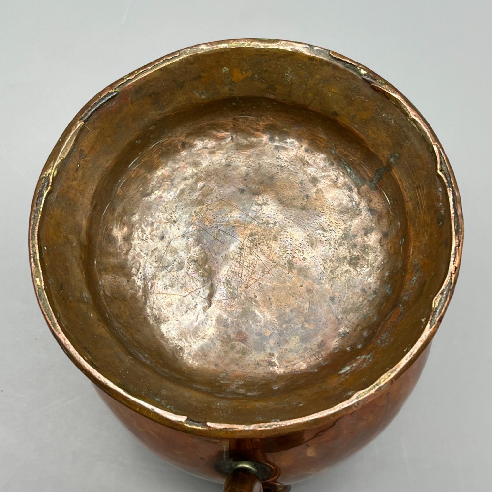 A Georgian copper jug featuring a bulbous body, a flared circular base, a pinched pouring spout, and a large curved loop handle. View XVIII