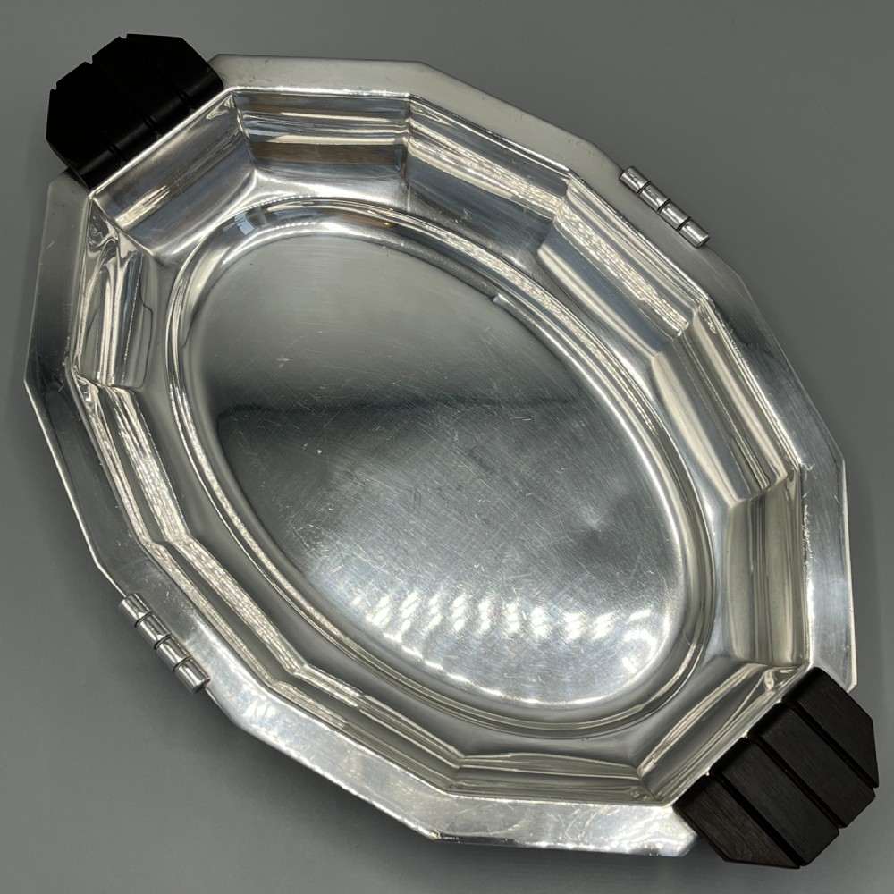 An octagonal silver-plated serving dish featuring faceted sides and carved dark wooden handles on opposite ends. View IV