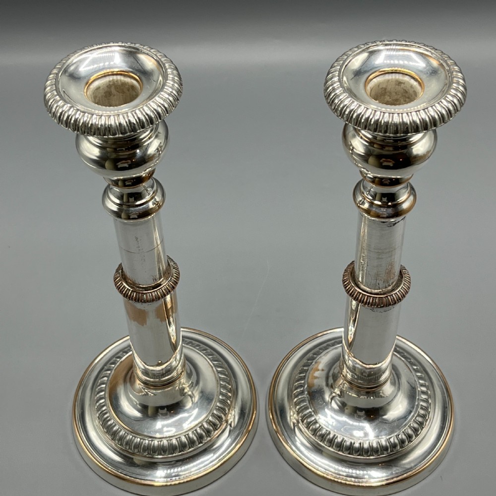 A pair of silver plated telescopic candlesticks featuring gadrooned borders and circular stepped bases. View II