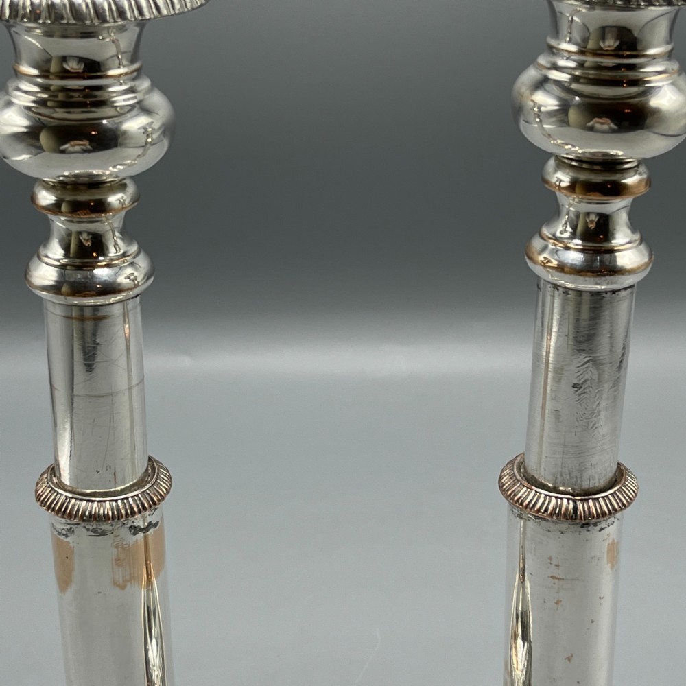 A pair of silver plated telescopic candlesticks featuring gadrooned borders and circular stepped bases. View IV
