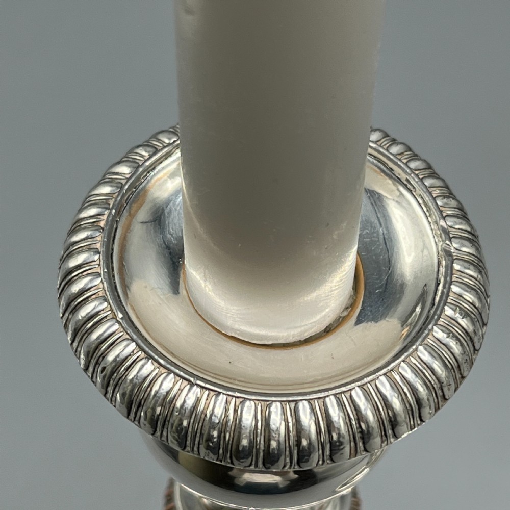 A pair of silver plated telescopic candlesticks featuring gadrooned borders and circular stepped bases. View V