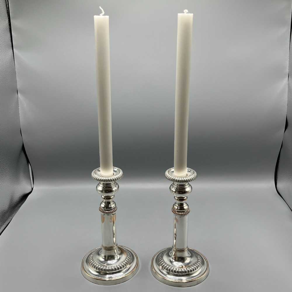 A pair of silver plated telescopic candlesticks featuring gadrooned borders and circular stepped bases. View VII