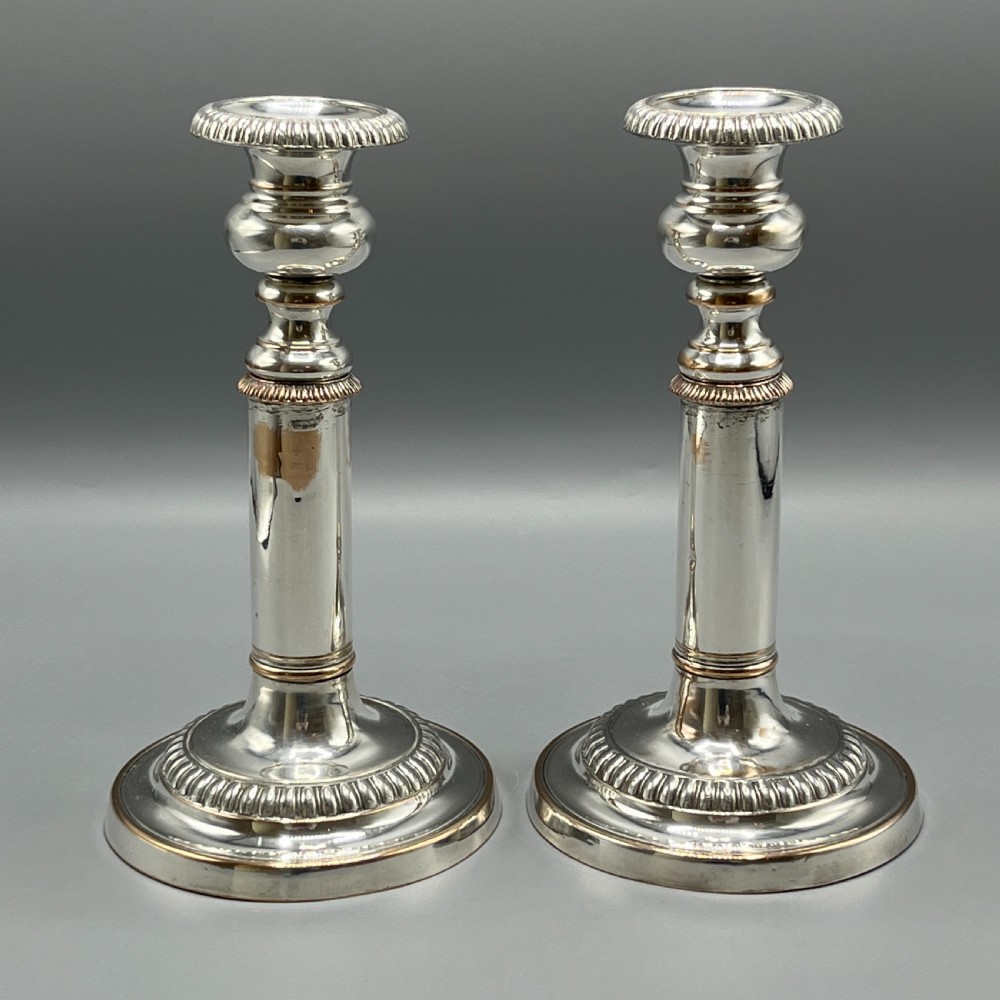 A pair of silver plated telescopic candlesticks featuring gadrooned borders and circular stepped bases. View VIII