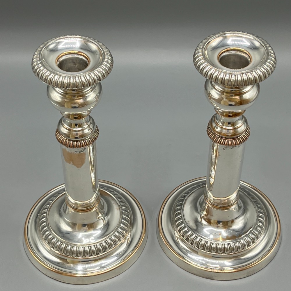 A pair of silver plated telescopic candlesticks featuring gadrooned borders and circular stepped bases. View IX