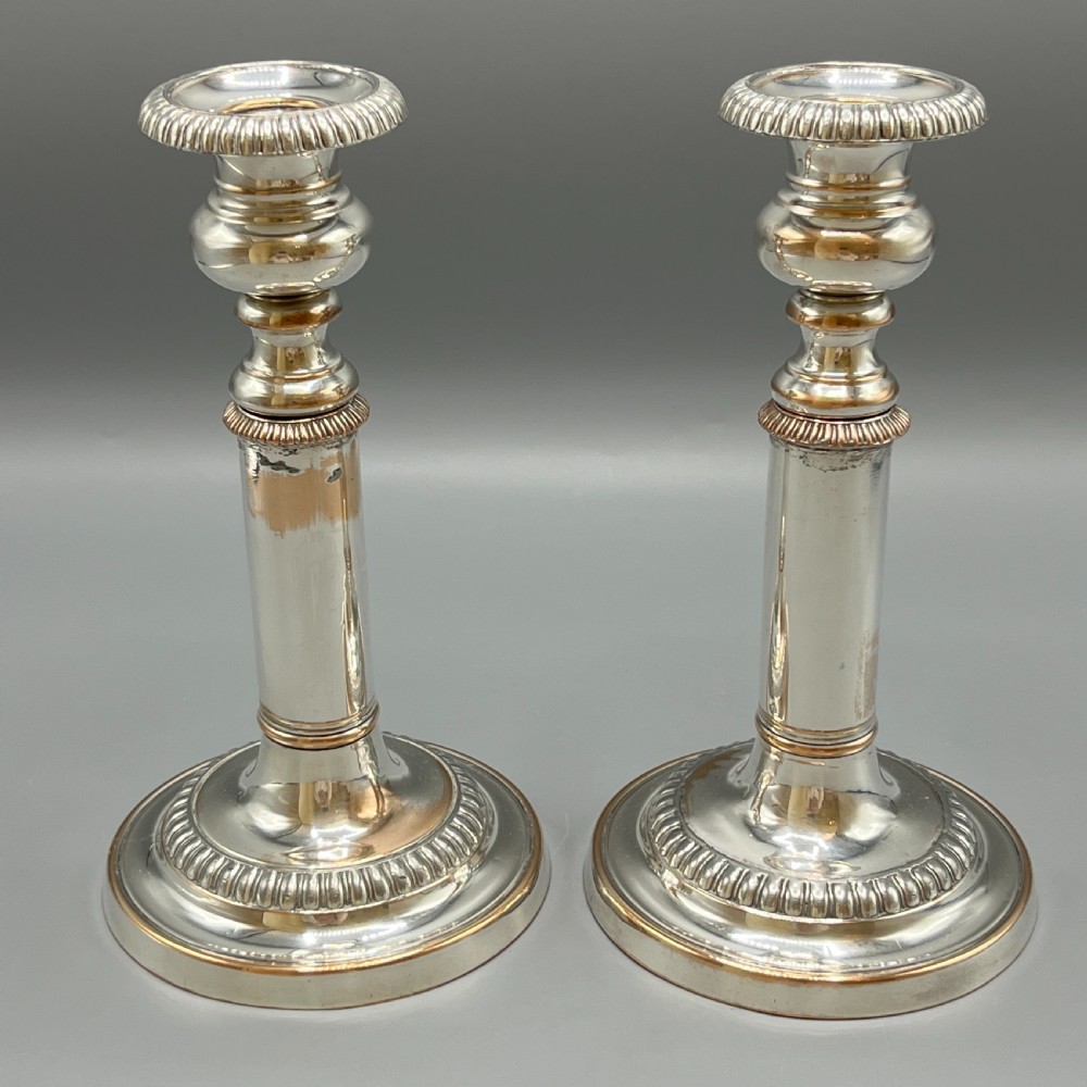 A pair of silver plated telescopic candlesticks featuring gadrooned borders and circular stepped bases. View XI