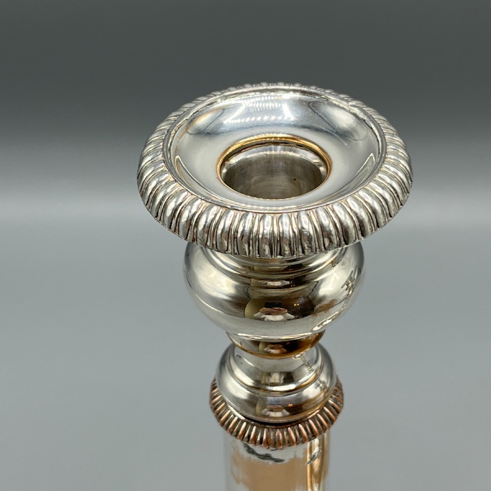 A pair of silver plated telescopic candlesticks featuring gadrooned borders and circular stepped bases. View XIV