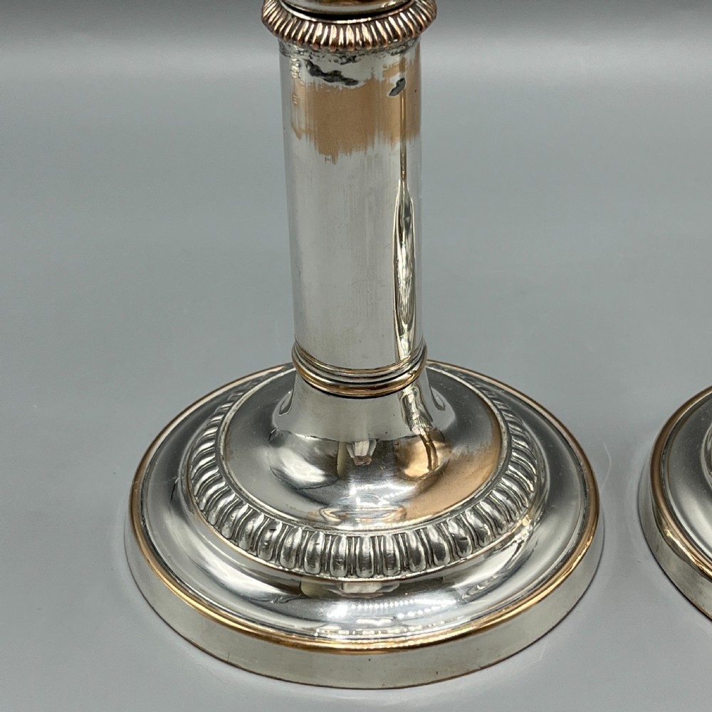 A pair of silver plated telescopic candlesticks featuring gadrooned borders and circular stepped bases. View XV