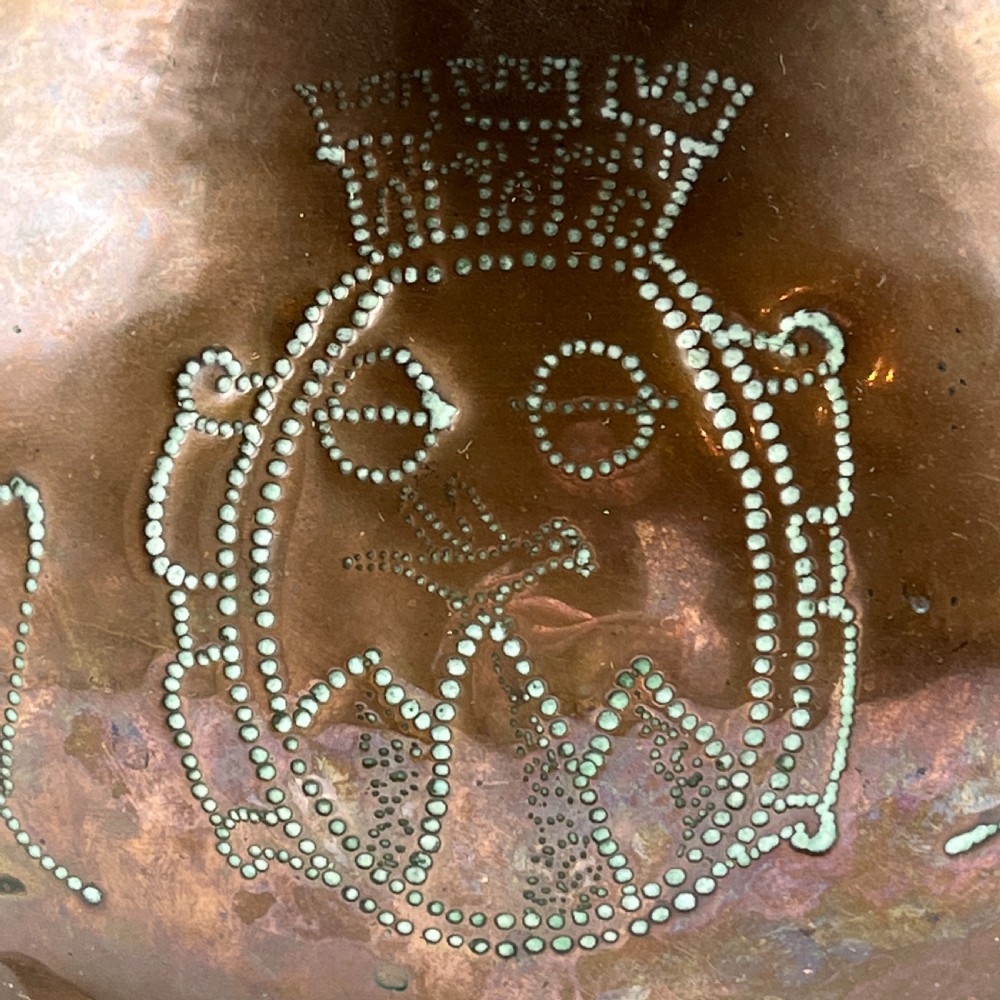 A solid copper Arts and Crafts jardiniere featuring a crimped ruffled rim, dot-punched floral motifs, and riveted splayed legs. View IV