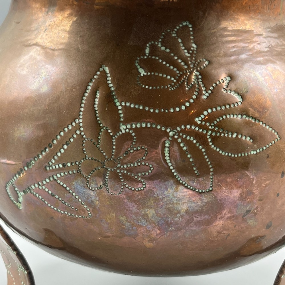 A solid copper Arts and Crafts jardiniere featuring a crimped ruffled rim, dot-punched floral motifs, and riveted splayed legs. View VI