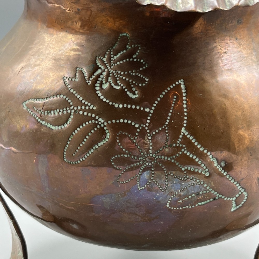 A solid copper Arts and Crafts jardiniere featuring a crimped ruffled rim, dot-punched floral motifs, and riveted splayed legs. View VII
