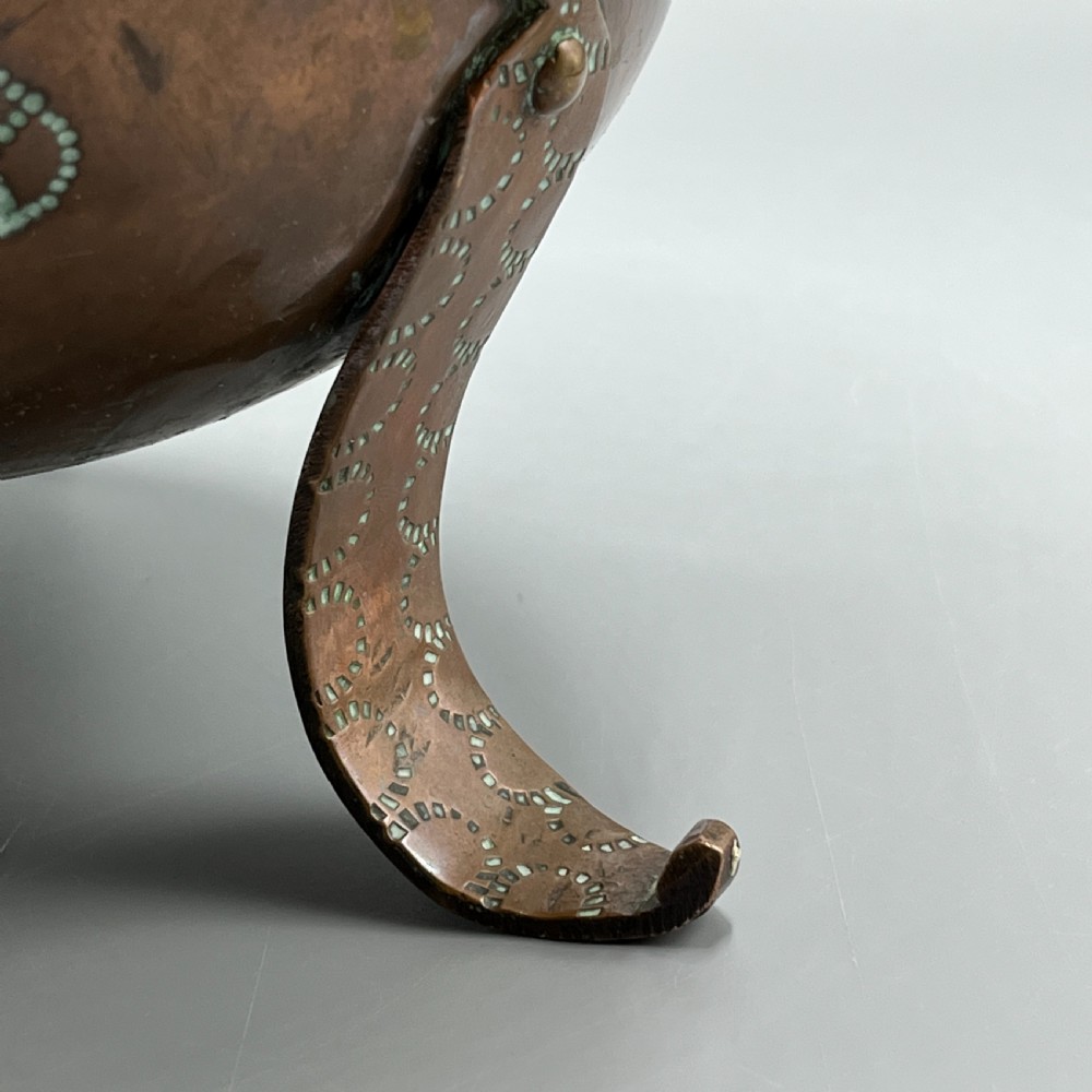 A solid copper Arts and Crafts jardiniere featuring a crimped ruffled rim, dot-punched floral motifs, and riveted splayed legs. View XII