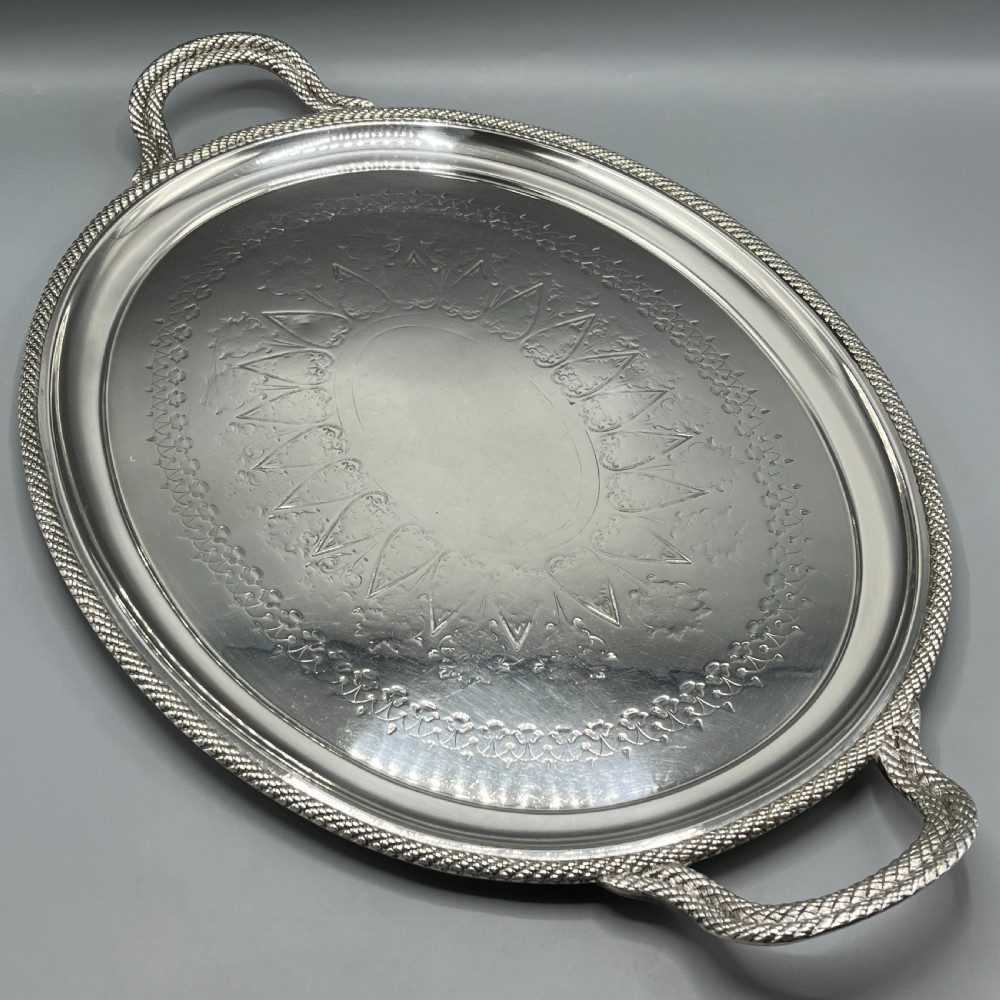 A large Victorian oval silver-plated serving tray featuring twin carrying handles, a textured rope border, and elaborate floral central engraving. View II