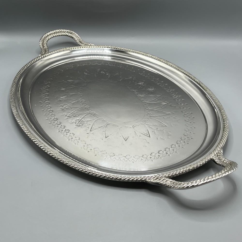 A large Victorian oval silver-plated serving tray featuring twin carrying handles, a textured rope border, and elaborate floral central engraving. View III