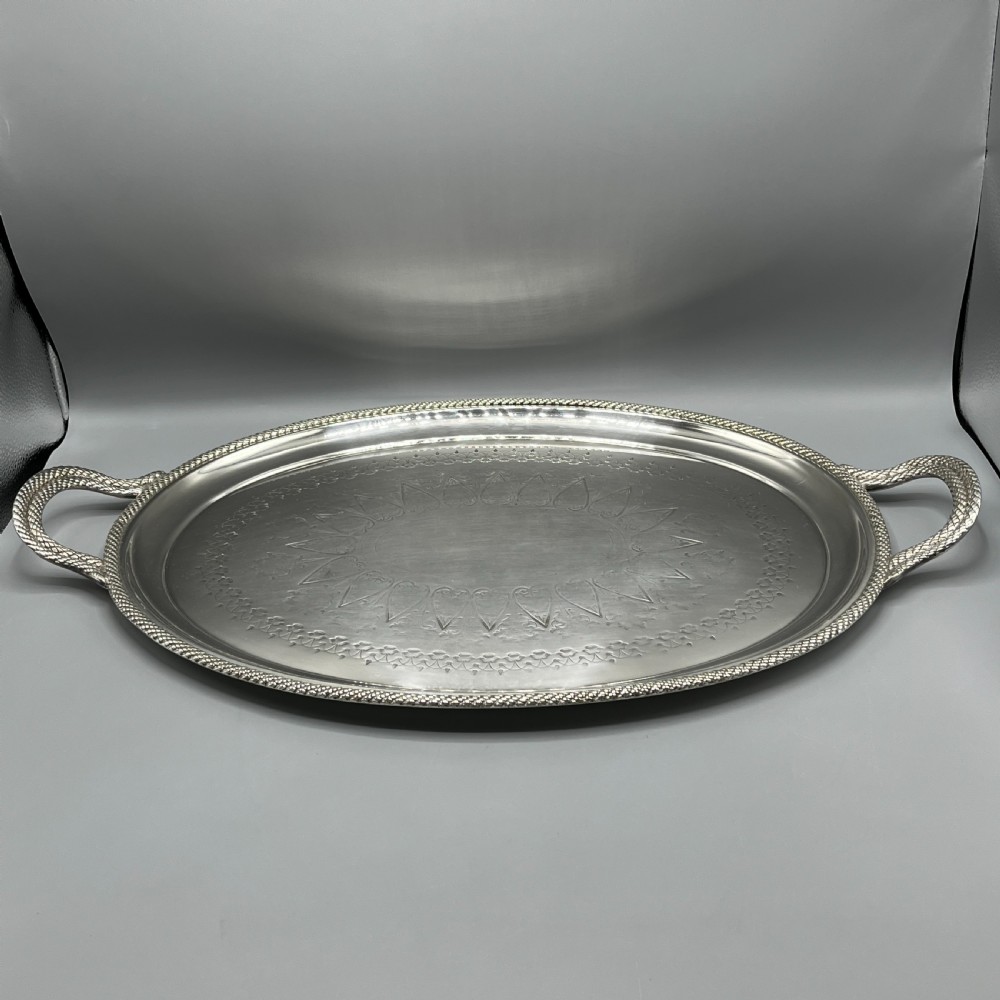 A large Victorian oval silver-plated serving tray featuring twin carrying handles, a textured rope border, and elaborate floral central engraving. View IV