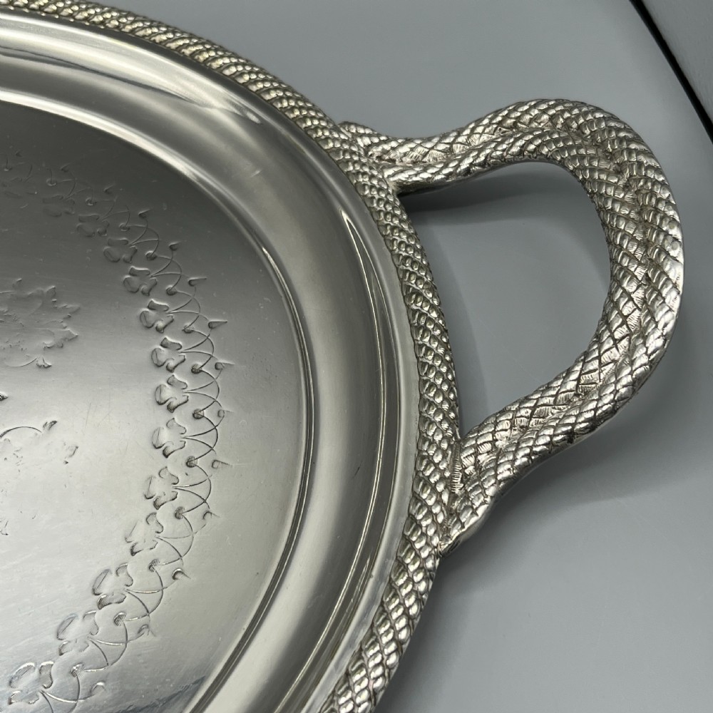 A large Victorian oval silver-plated serving tray featuring twin carrying handles, a textured rope border, and elaborate floral central engraving. View XI