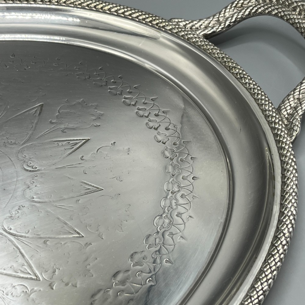 A large Victorian oval silver-plated serving tray featuring twin carrying handles, a textured rope border, and elaborate floral central engraving. View XV
