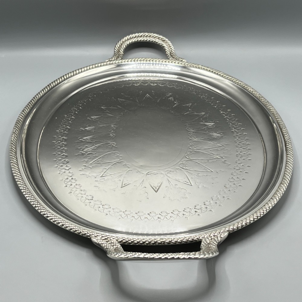 A large Victorian oval silver-plated serving tray featuring twin carrying handles, a textured rope border, and elaborate floral central engraving. View XVI