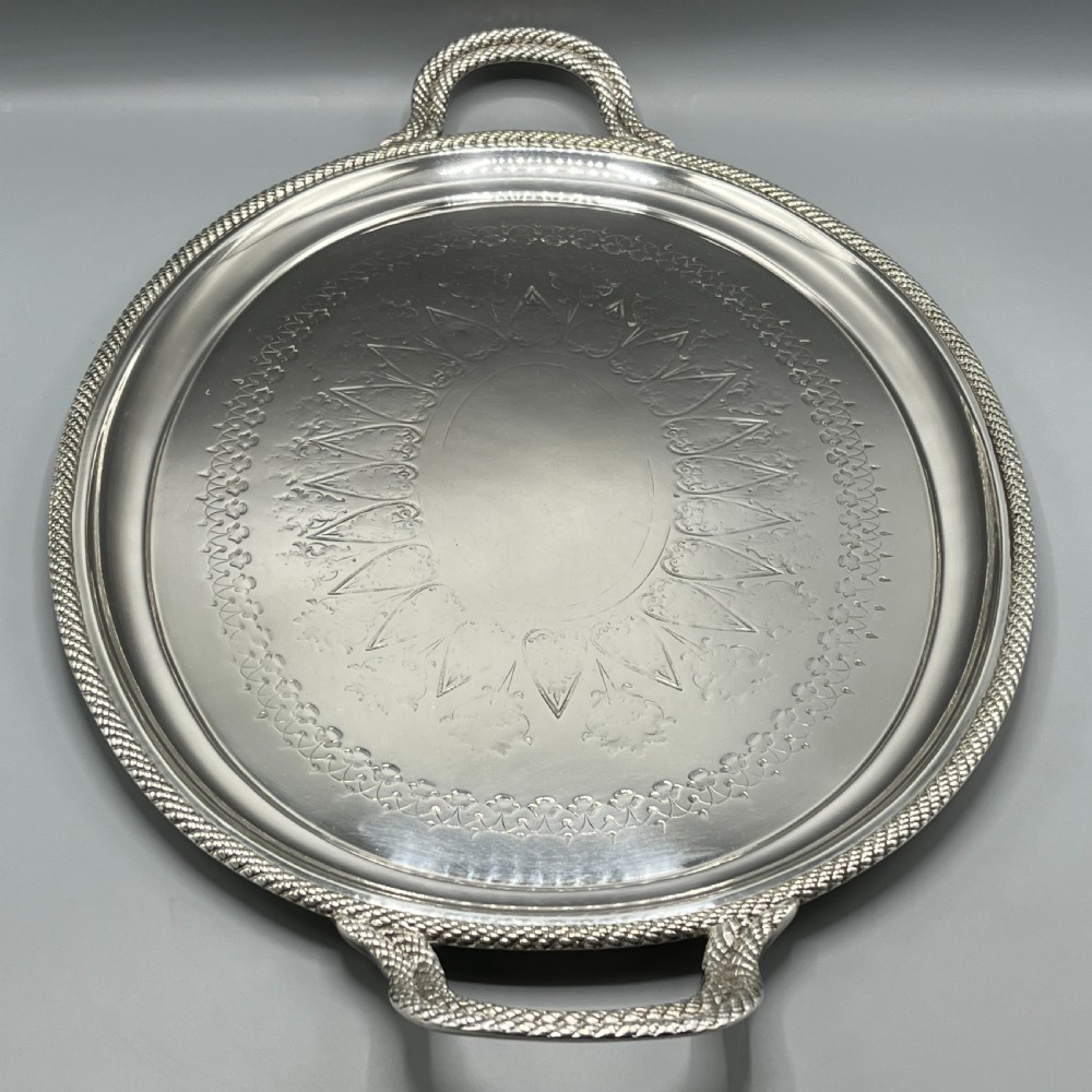 A large Victorian oval silver-plated serving tray featuring twin carrying handles, a textured rope border, and elaborate floral central engraving. View XVII