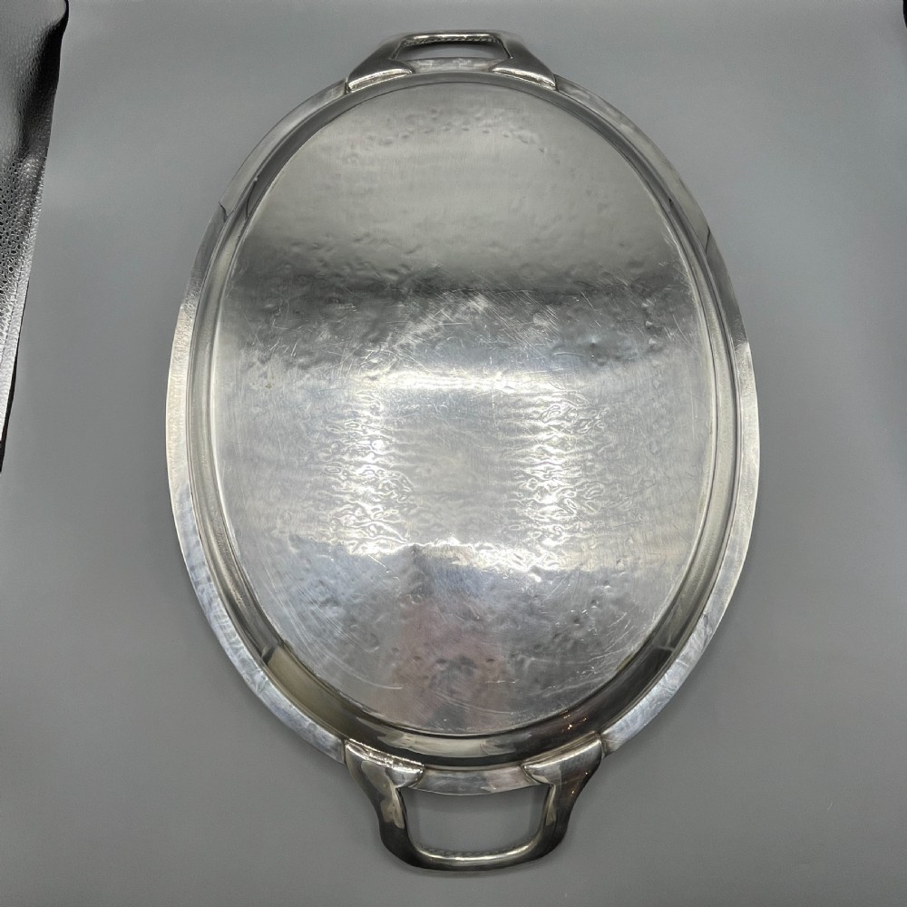 A large Victorian oval silver-plated serving tray featuring twin carrying handles, a textured rope border, and elaborate floral central engraving. View XX