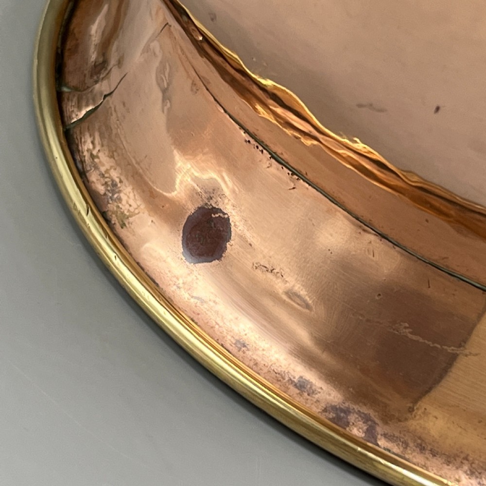 A large polished oval copper jardiniere with a flared rim edged in brass and a fitted flared brass base. View IX
