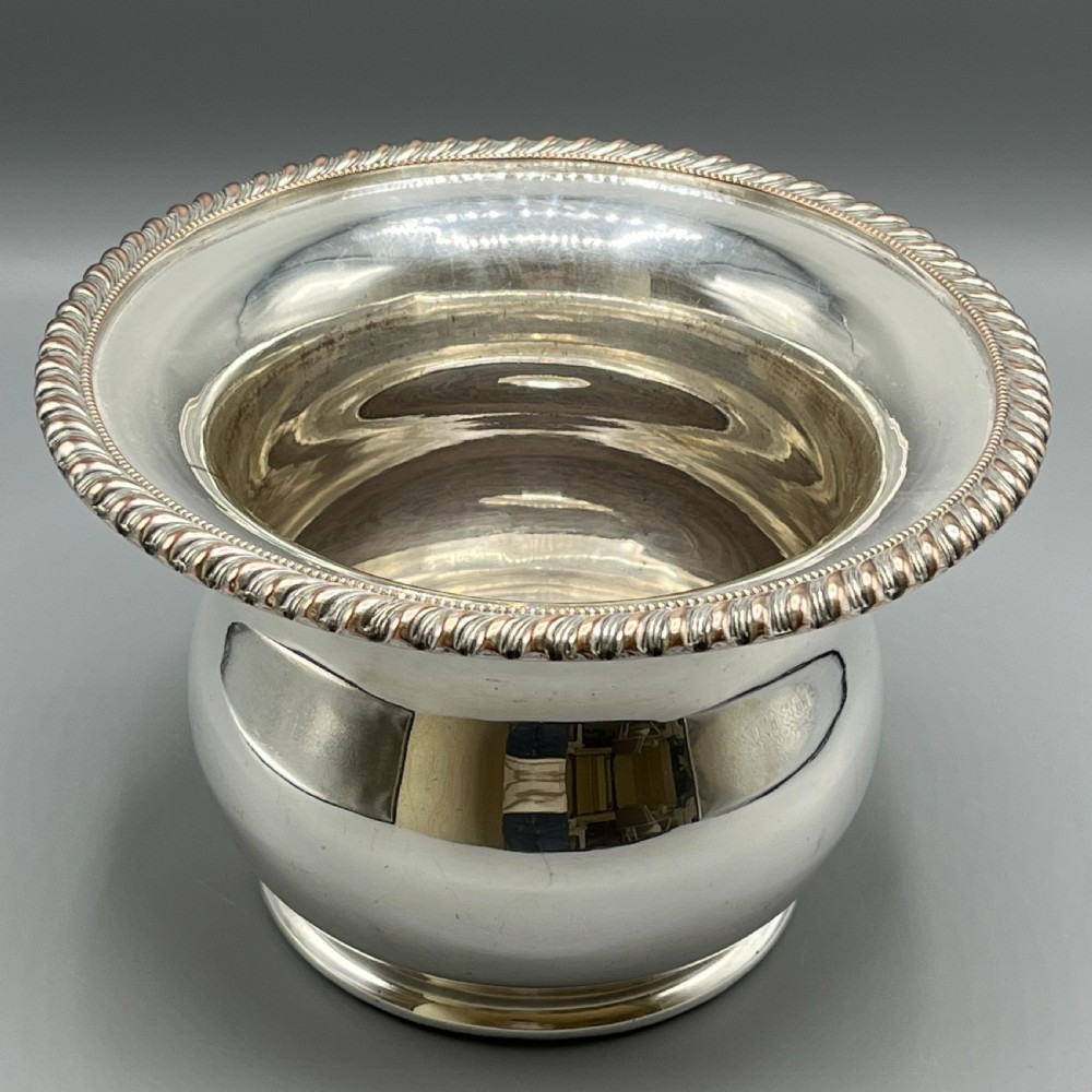 A circular silver-plated wine bottle coaster featuring a rope-twist detailed rim and a flared, polished body. View II