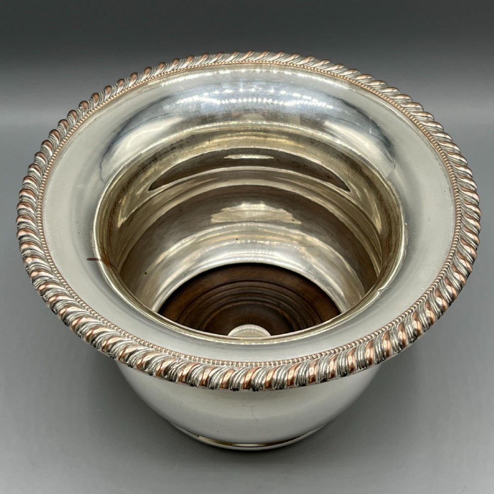 A circular silver-plated wine bottle coaster featuring a rope-twist detailed rim and a flared, polished body. View III