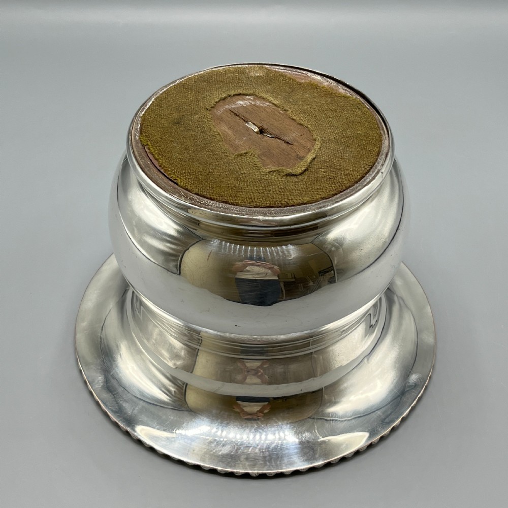 A circular silver-plated wine bottle coaster featuring a rope-twist detailed rim and a flared, polished body. View XII