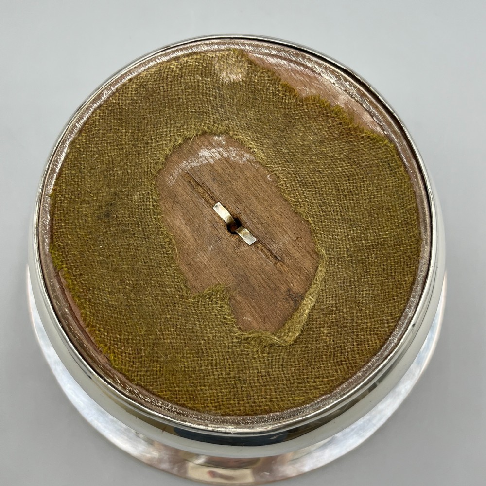 A circular silver-plated wine bottle coaster featuring a rope-twist detailed rim and a flared, polished body. View XIII