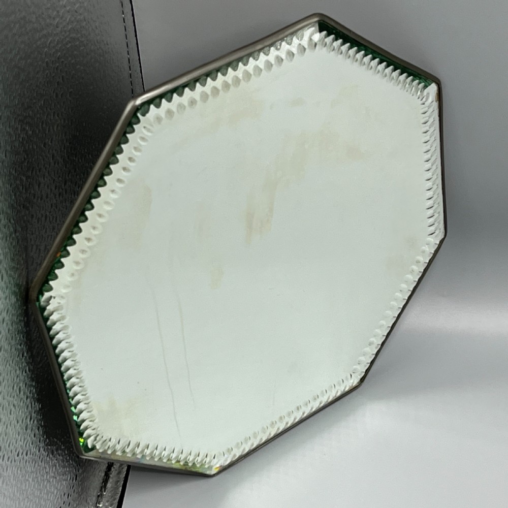 An octagonal frameless mirror featuring a decoratively cut bevelled interior border pattern on a clear mirrored surface. View V