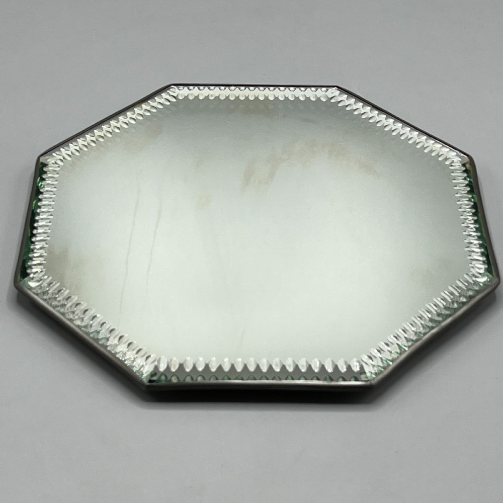 An octagonal frameless mirror featuring a decoratively cut bevelled interior border pattern on a clear mirrored surface. View VI