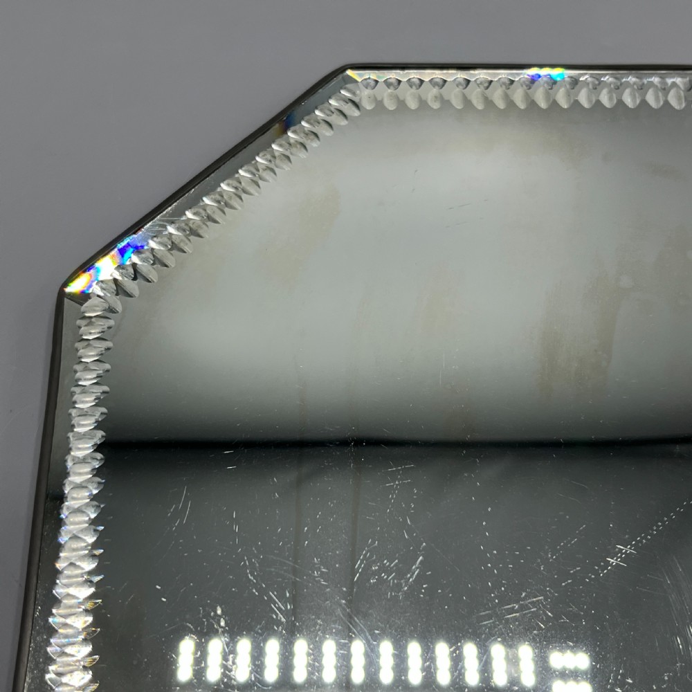 An octagonal frameless mirror featuring a decoratively cut bevelled interior border pattern on a clear mirrored surface. View XI