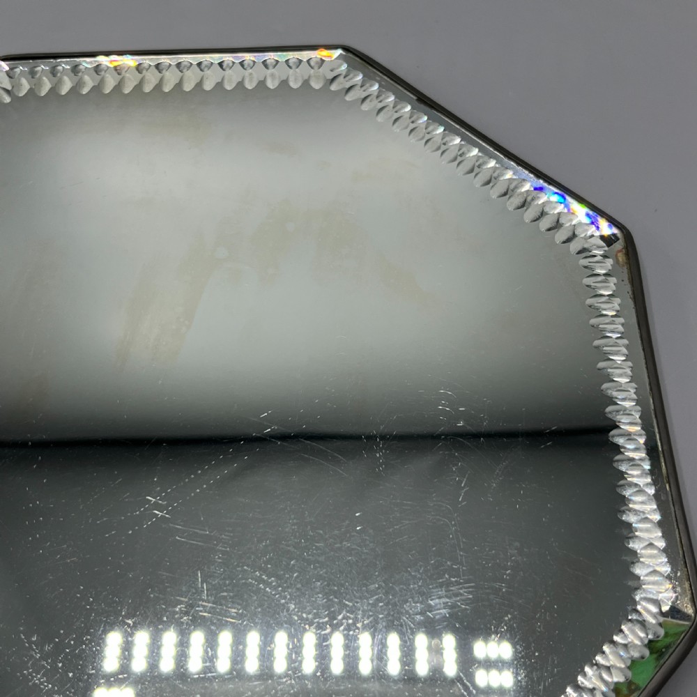 An octagonal frameless mirror featuring a decoratively cut bevelled interior border pattern on a clear mirrored surface. View XII
